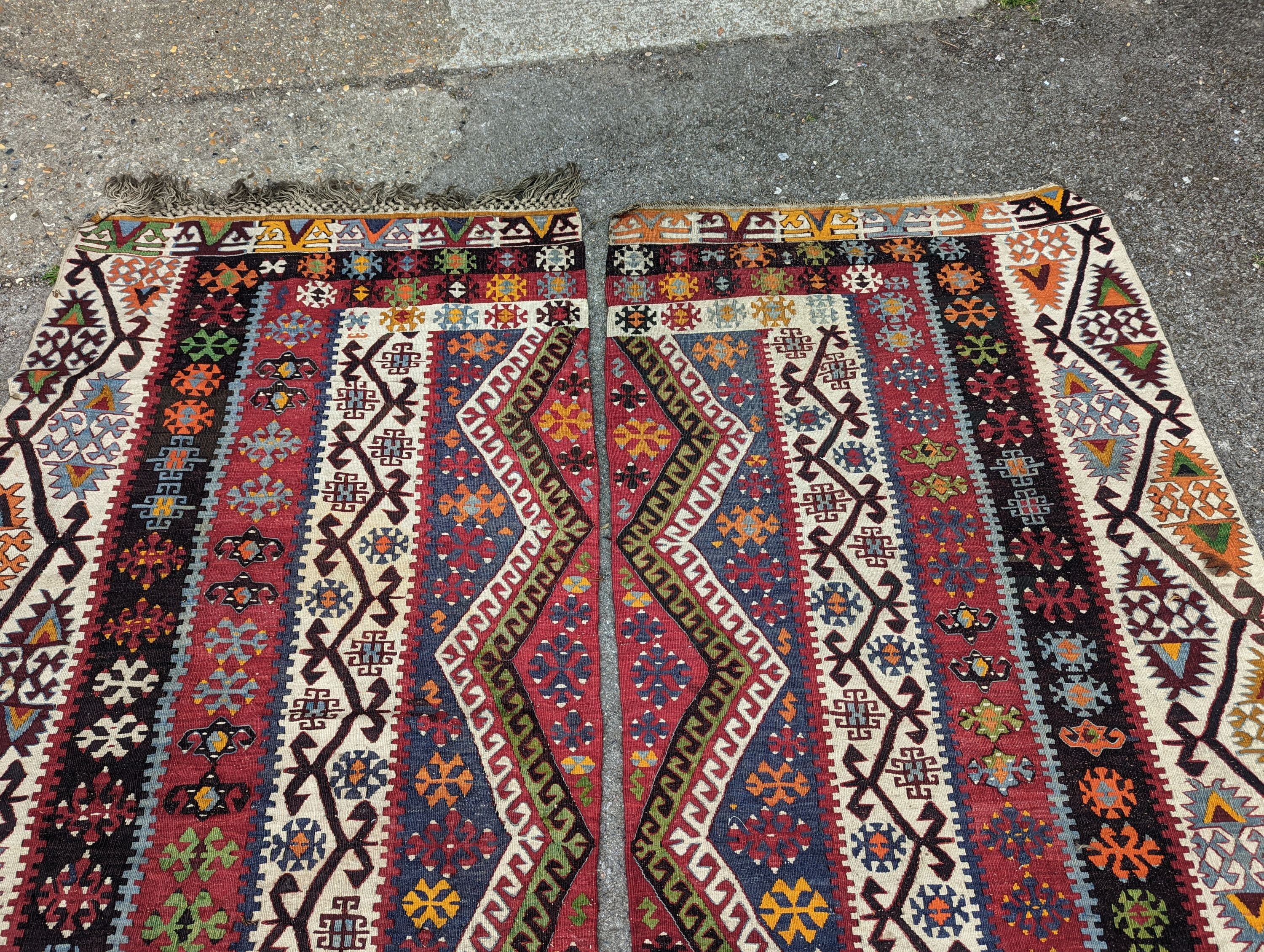 A Kilim polychrome flatweave carpet, cut centrally to create a pair of runners, each 440 x 97cm